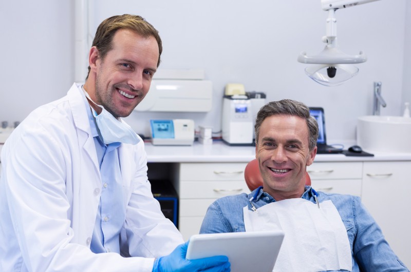 dentist-discussing-over-digital-tablet-with-male
